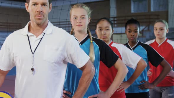 Male coach and volleyball players standing in a row 