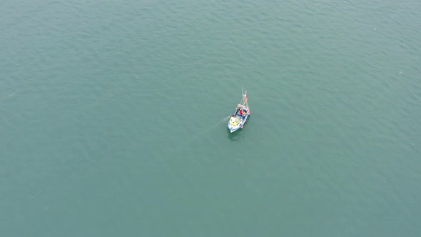 Fishing Boat Pulling Nets on a Grey Day From the Air