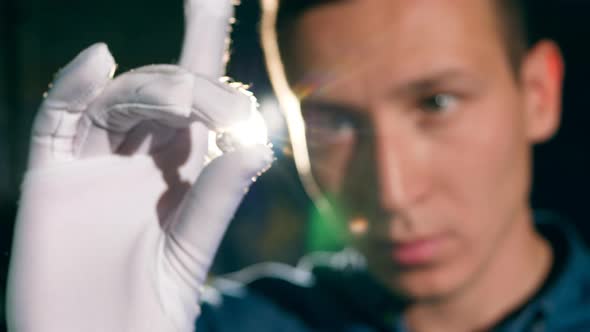 Male Jeweler Is Looking at the Gemstone Against the Light. Jeweler Makes a Piece of Jewelry