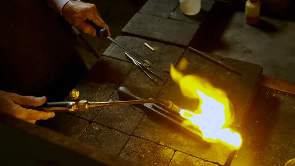 Goldsmith using welding torch in workshop 4k
