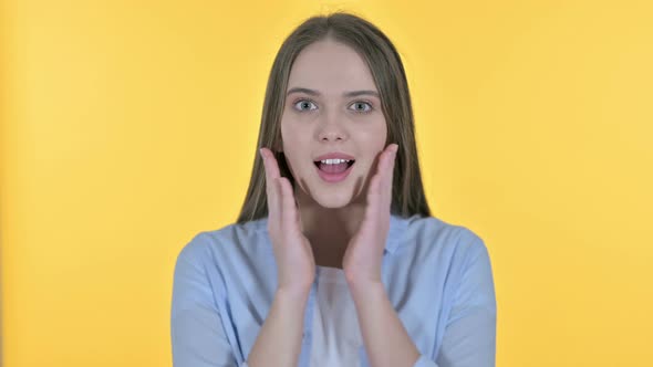 Young Woman Excited for Surprise, Yellow Background