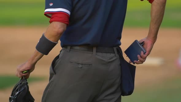 The umpire at a baseball game with his score notepad.