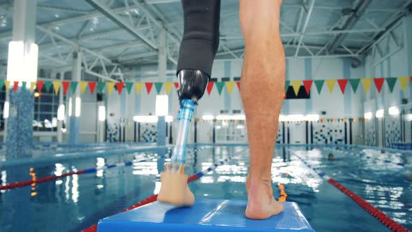 Swimmer with a Leg Prosthesis Training Near a Pool, Bionic Equipment