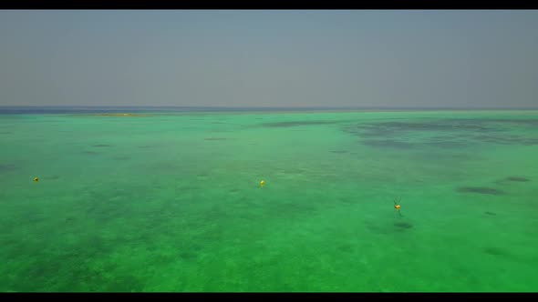 Aerial scenery of perfect seashore beach break by clear ocean and white sandy background of a dayout