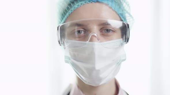 A Female Doctor in Medical Uniform is Looking at Camera at Hospital Close Up