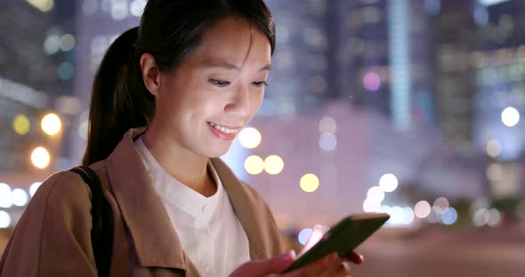 Asian Business woman use of mobile phone in city at night