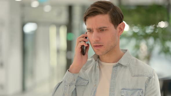 Portrait of Aggressive Creative Young Man Angry on Smartphone