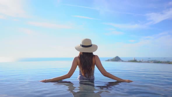 Young asian woman enjoy around outdoor swimming pool for leisure