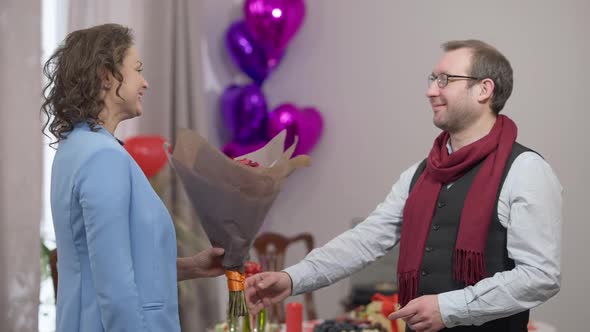 Side View Portrait of Smiling Man Giving Bouquet of Flowers to Woman and Thankful Wife Hugging / Videohive