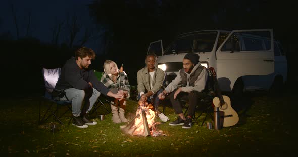 Multiracial Friends Having a Picnic By Fire