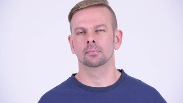 Head Shot of Blonde Man Wearing Blue Shirt Against White Background