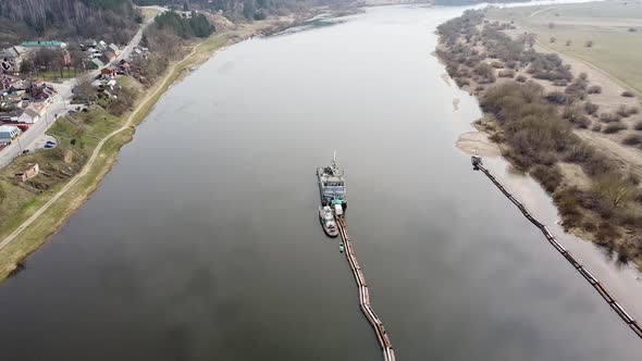 Dredger ship deepening Nemunas river, aerial drone view