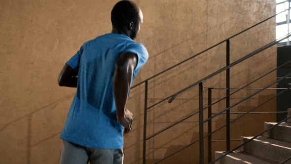 Workout. Runner man running up stairs, training indoors