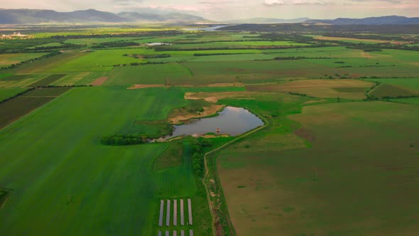 Aerial drone footage over green ground and lake