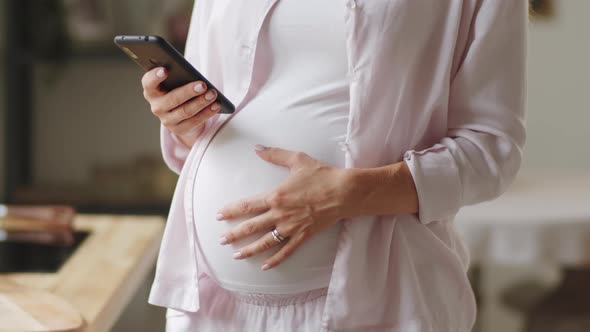Pregnant Woman Using Smartphone at Home