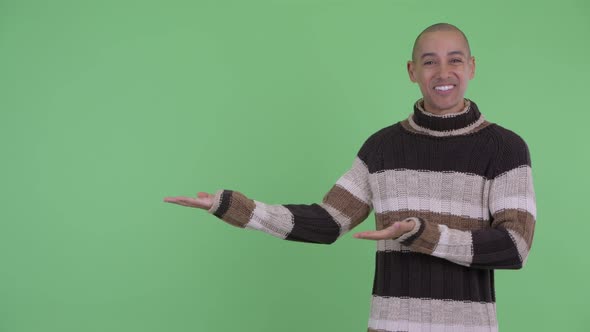 Happy Bald Multi Ethnic Man Showing Something