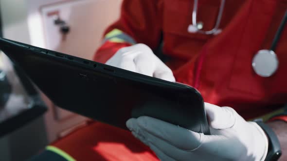 Unrecognizable Doctor Using Tablet in Ambulance