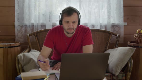 Young Man in Headphones Studying Online By Distance Webinar, E-learning