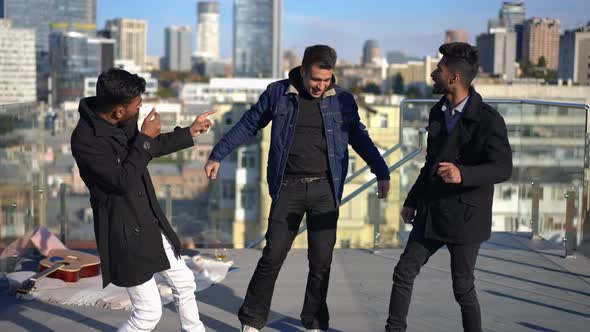 Wide Shot Three Relaxed Men Dancing on Rooftop on Sunny Day in Urban City