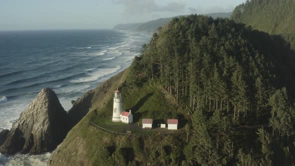 Wide circumnavigating aerial revealing Haceta Head lighthouse in Oregon