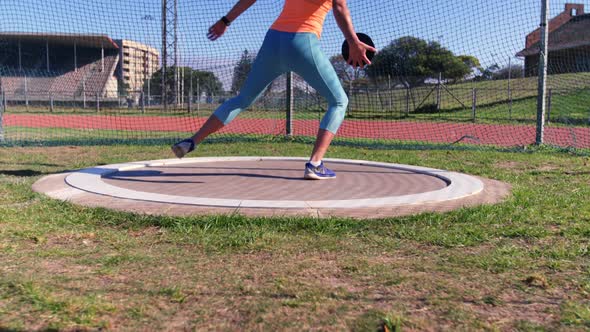 Side view of Caucasian female athlete practicing discus throw at sports venue 4k