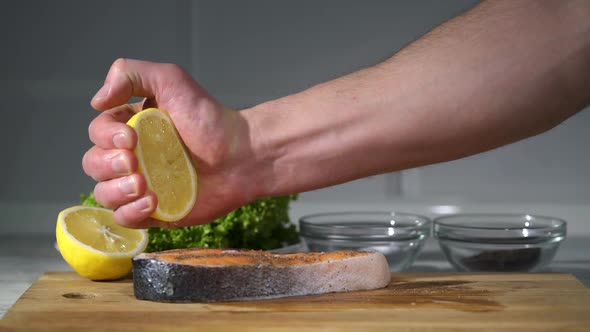 The Cook Squeezes the Lemon Juice on the Steak.