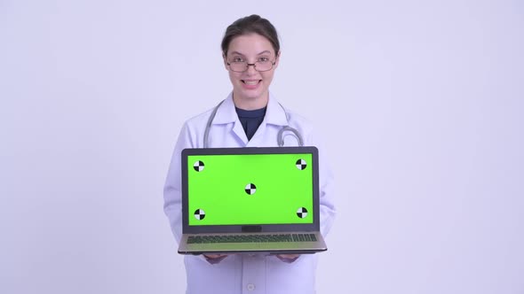 Happy Young Beautiful Woman Doctor Talking While Showing Laptop