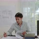 male architect or engineer is busy with his work on a desk full of house blueprints and computers - VideoHive Item for Sale
