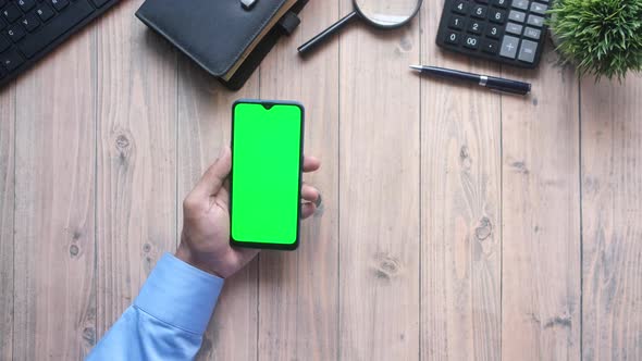 Top View of Man Hand Using Smart Phone on Office Desk