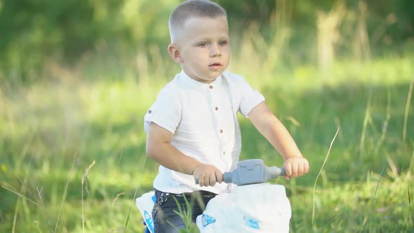 Boy Sits on a Plastic Bike