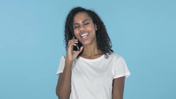 African Girl Talking on Smartphone Isolated on Blue Background