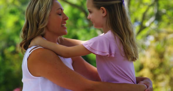 Happy mother embracing her daughter in park 4k