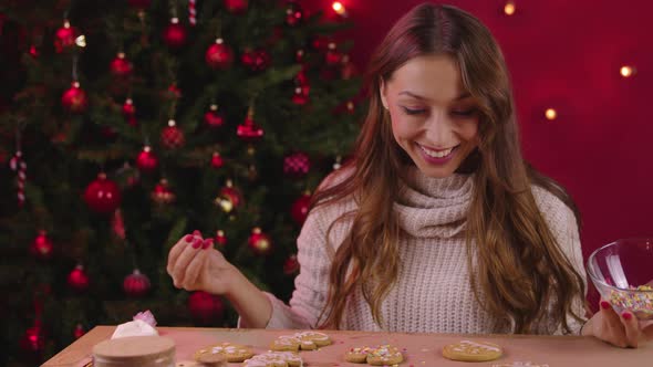 Pretty Brunette Girl Decorating Christmas Cookies in Xmas Decoration Self-gifter