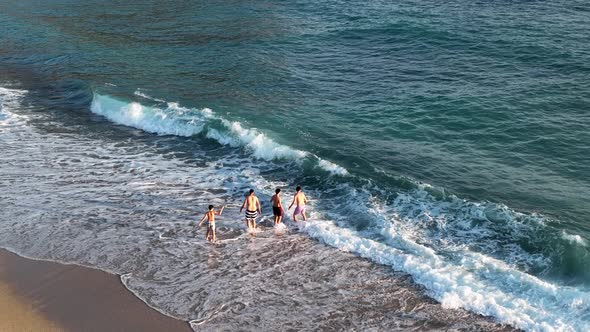 Friends play on the sea waves of the beach aerial view 4 K