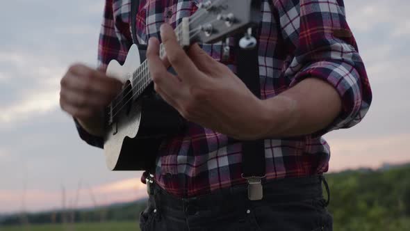 Close Up Man's Hands on Guitar's Stripes