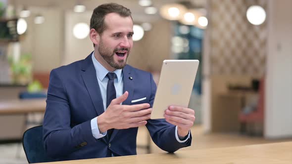 Excited Businessman Celebrating Success on Tablet