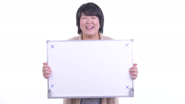 Happy Overweight Asian Woman Holding White Board and Getting Good News for Winter