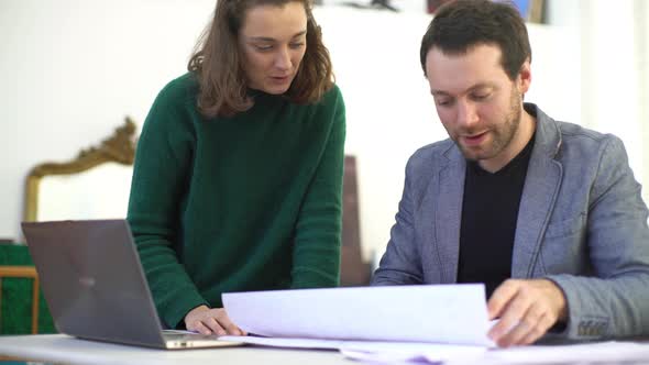 Colleagues shaking hands while collaborating in office