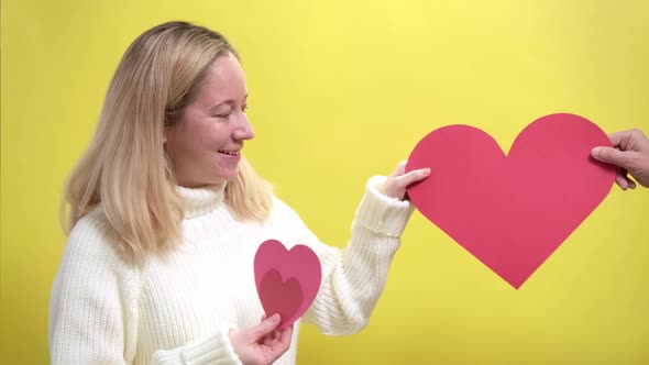 Blond Girl Accepting a Gift in the Form of Paper Heart