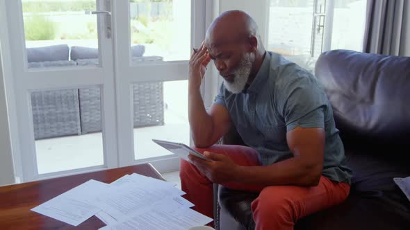 Side view of mature man signing documents in living room at home 4k