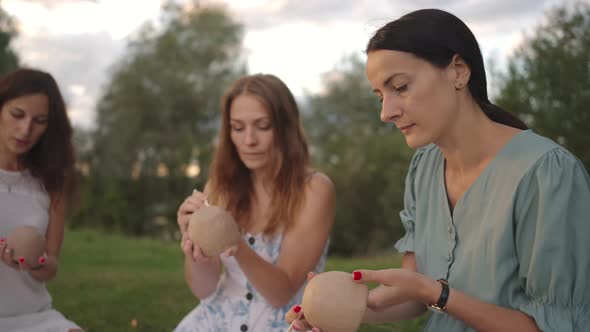 A Group of Young Women are Concentrating on Applying Patterns to Clay Products with the Help of