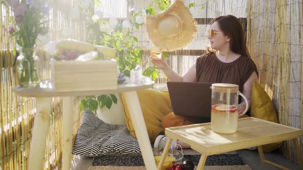 Woman Using Laptop on Summer Terrace