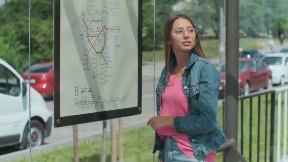 Woman Looking on the Scheme of Public Transport While Standing at the Tram Station Outdoors.