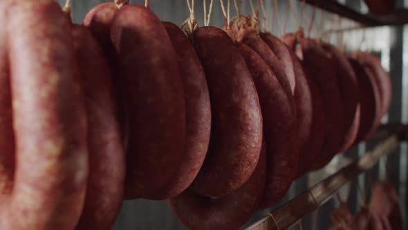 Meat industry, lot of raw sausage is weighed on frame before being immersed in oven chamber.