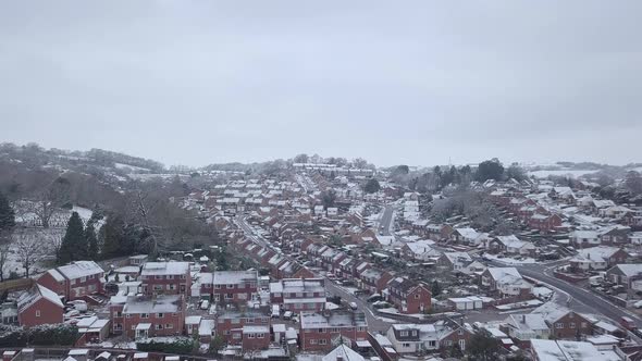 Ascending dolly forward drone shot of snowy Exeter subburbs