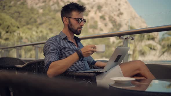 Freelancer Works Outdoors On Computer. Man Working On Laptop In Vocation.