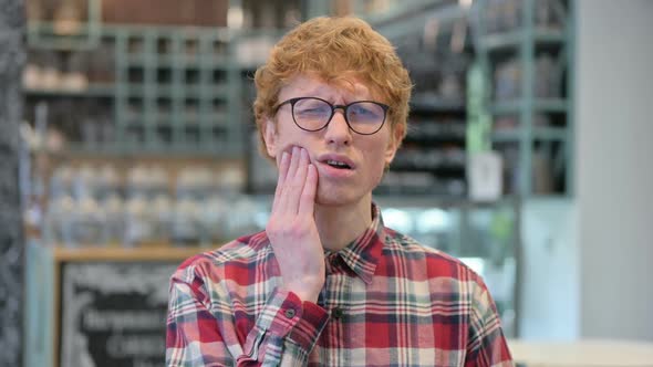 Young Redhead Man with Toothache Cavity