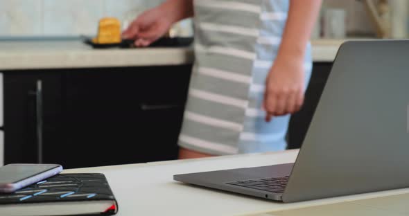 Lady Sits at Table with Grey Laptop