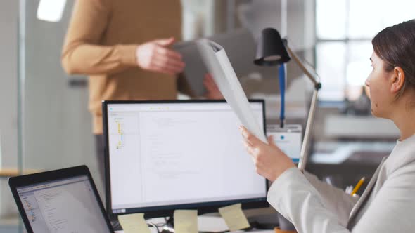 Programmer Giving Folder To Colleague at Office 7