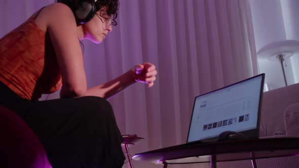 Young Woman Listening To A Podcast At Home